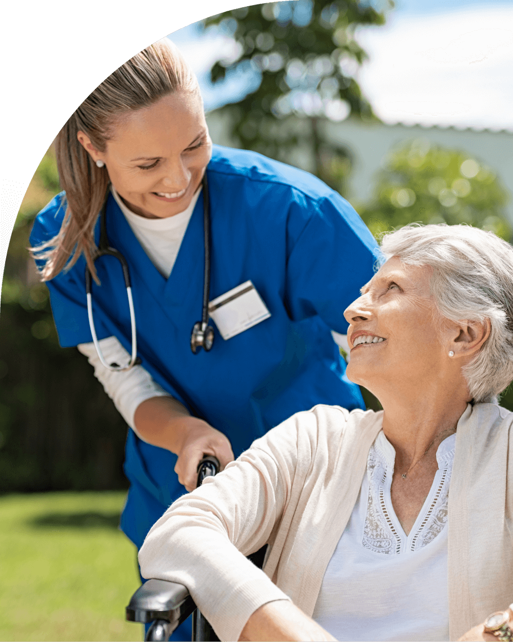 Nurse talking with a happy elderly woman in a wheelchair
