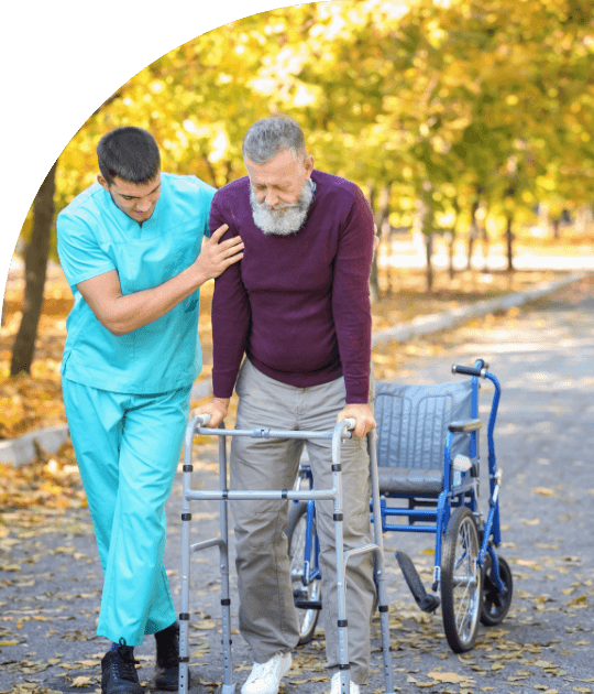 Disability support worker assists an elderly man with a walker outdoors, promoting mobility and independence in Carlton